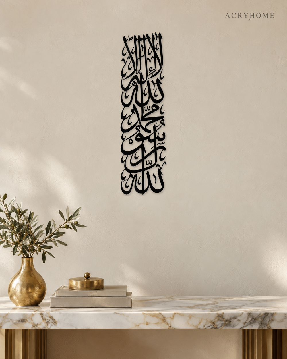 Tall vertical Kalima calligraphy in gloss piano black acrylic, stacked Thuluth lines float-mounted on a pale plaster wall above a console table