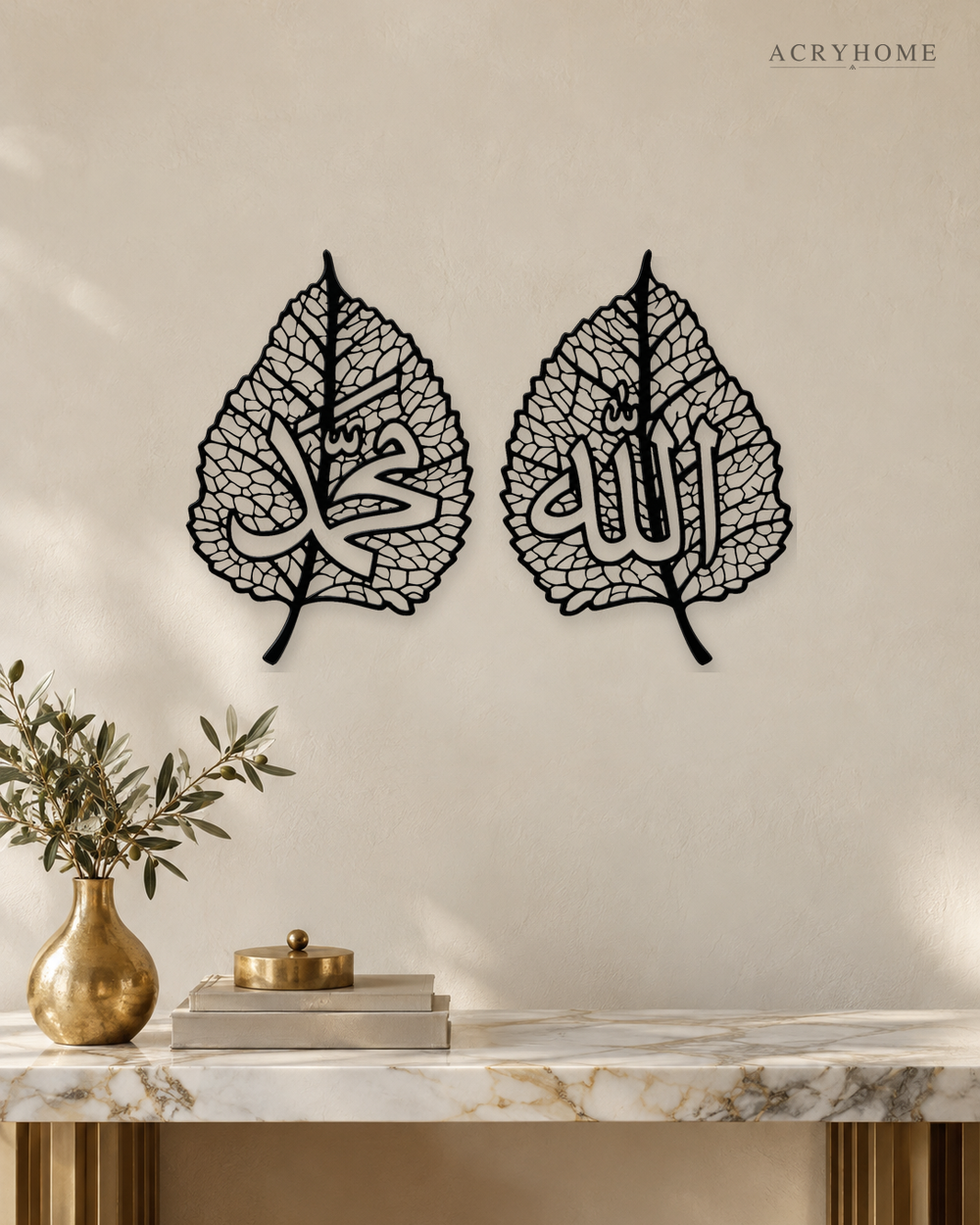 Set of two gloss black acrylic leaf panels with fine vein lattice and Arabic calligraphy at the centre of each, float-mounted on a pale wall