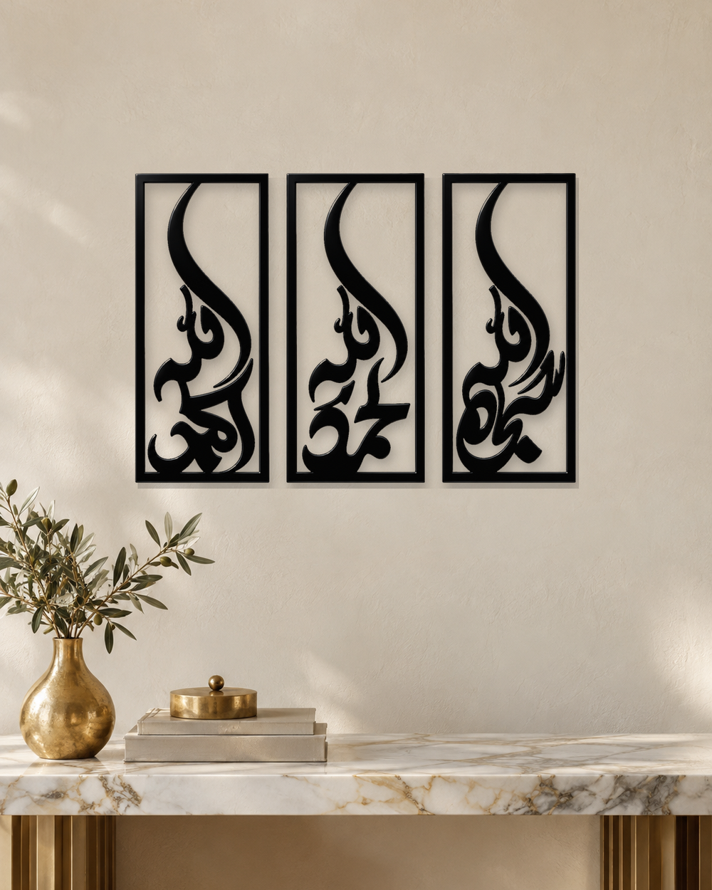 Set of three narrow vertical acrylic wall panels in gloss piano black, each framing a single Arabic word in tall flowing calligraphy, float-mounted in a row on a pale wall.