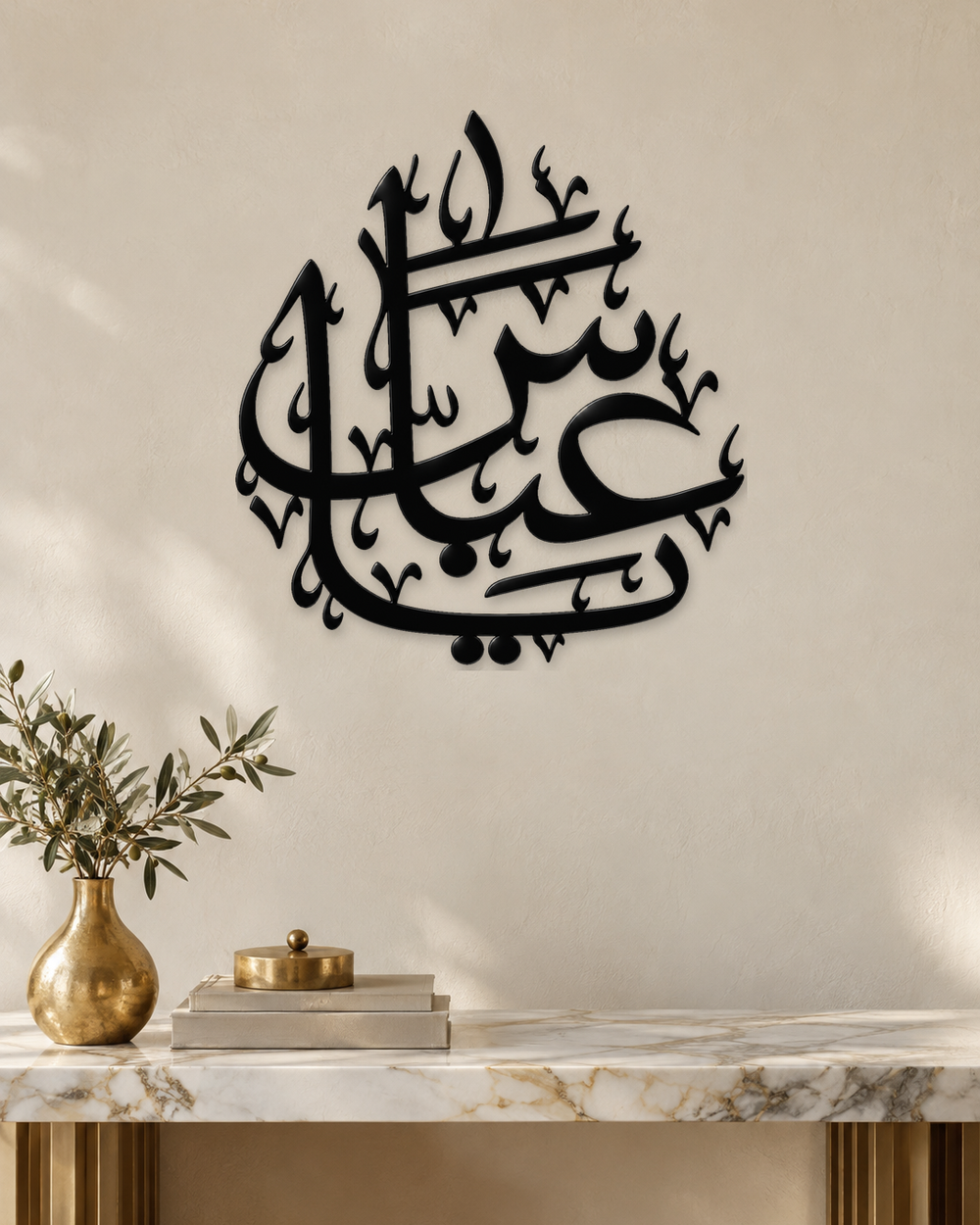 Arabic name calligraphy wall piece in gloss piano black acrylic, float-mounted above a pale console table.