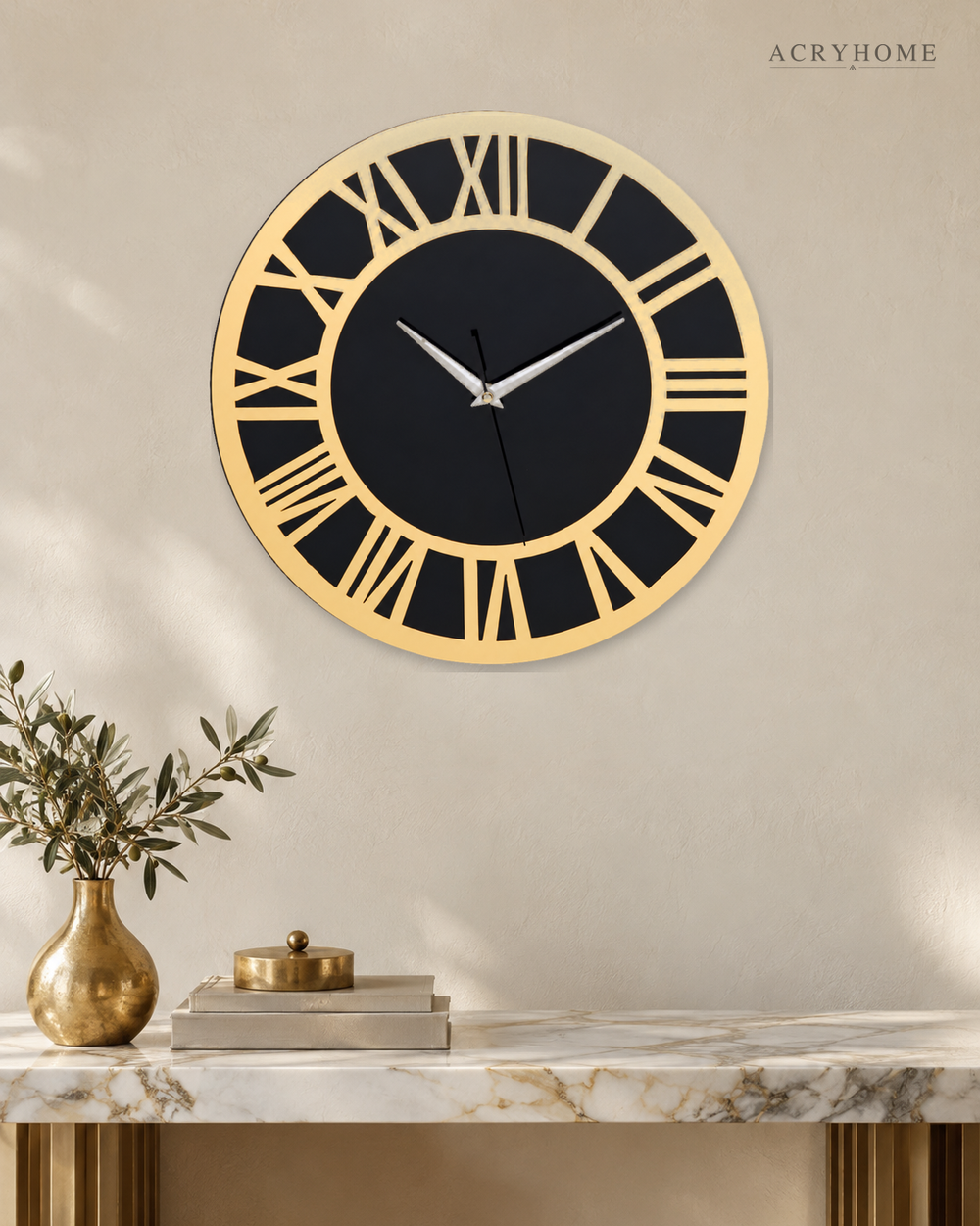 Round Roman numeral wall clock in gold mirror and black acrylic, on a pale wall.