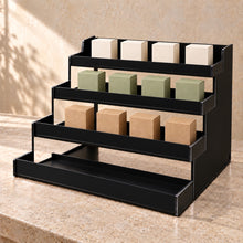 Four-Tier Retail Product Display in black acrylic, in use