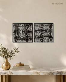 Set of two square Kufic acrylic panels, Surah Al-Falaq and Surah An-Nas, in gloss piano black, float-mounted side by side on a pale wall.