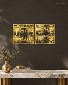 Set of two square Kufic acrylic panels, Surah Al-Falaq and Surah An-Nas, in mirror gold, float-mounted side by side on a pale wall.