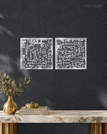 Set of two square Kufic acrylic panels, Surah Al-Falaq and Surah An-Nas, in mirror silver, float-mounted side by side on a pale wall.