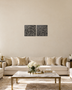 Set of two square Kufic acrylic panels, Surah Al-Falaq and Surah An-Nas, in gloss piano black, float-mounted side by side on a pale wall.
