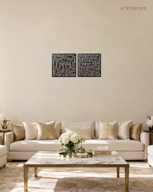 Set of two square Kufic acrylic panels, Surah Al-Falaq and Surah An-Nas, in gloss piano black, float-mounted side by side on a pale wall.