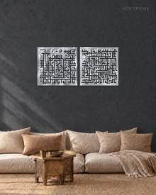 Set of two square Kufic acrylic panels, Surah Al-Falaq and Surah An-Nas, in mirror silver, float-mounted side by side on a pale wall.
