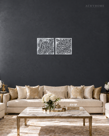 Set of two square Kufic acrylic panels, Surah Al-Falaq and Surah An-Nas, in mirror silver, float-mounted side by side on a pale wall.