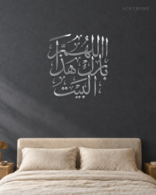 Bless this home Arabic calligraphy wall art in mirror silver acrylic, float-mounted on a neutral wall with a soft shadow behind the letters.