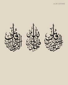 Set of three slim acrylic panels in gloss piano black, each carrying one short surah in vertical Arabic calligraphy, float-mounted on a pale wall.