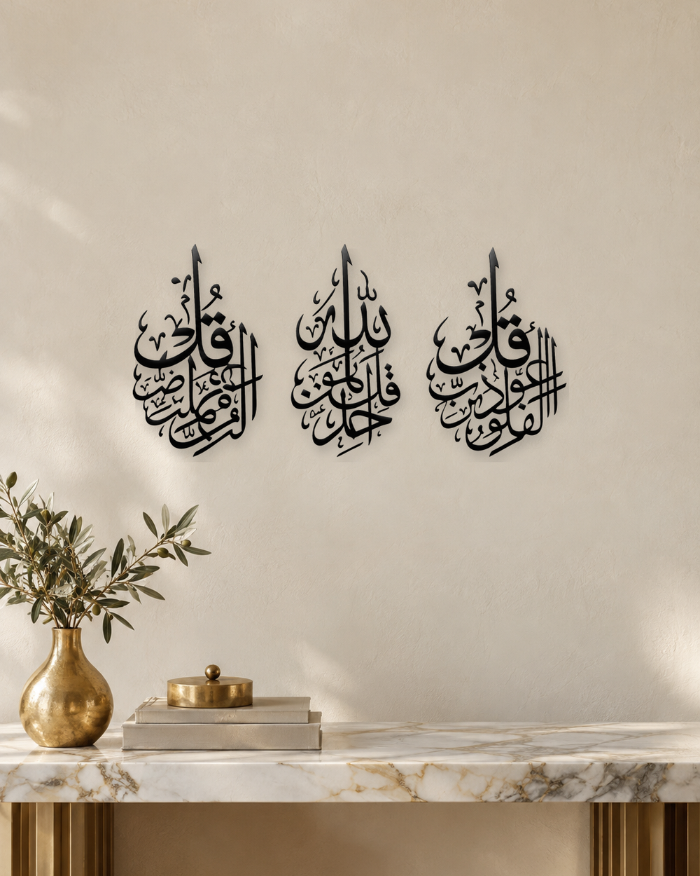 Set of three slim acrylic panels in gloss piano black, each carrying one short surah in vertical Arabic calligraphy, float-mounted on a pale wall.