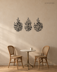 Set of three slim acrylic panels in gloss piano black, each carrying one short surah in vertical Arabic calligraphy, float-mounted on a pale wall.