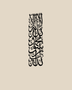 Tall vertical Kalima calligraphy in gloss piano black acrylic, stacked Thuluth lines float-mounted on a pale plaster wall above a console table