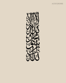 Tall vertical Kalima calligraphy in gloss piano black acrylic, stacked Thuluth lines float-mounted on a pale plaster wall above a console table