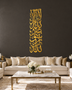 Mirror gold acrylic Kalima wall art in a tall vertical Thuluth composition, catching warm lamplight in a neutral hallway