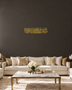 Panoramic Arabic Thuluth calligraphy of a dua for forgiveness, laser-cut acrylic wall art in mirror gold, float-mounted on a pale wall
