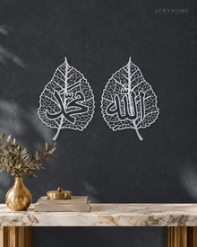 Two mirror silver acrylic leaf panels with delicate laser-cut veins and Arabic calligraphy, mounted side by side