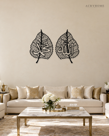 Set of two gloss black acrylic leaf panels with fine vein lattice and Arabic calligraphy at the centre of each, float-mounted on a pale wall