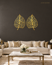 Pair of mirror gold acrylic leaf-shaped wall panels with open vein detail and Arabic calligraphy centred in each leaf