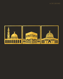 Three mirror gold acrylic panels of the holy mosques of Makkah, Madinah and Jerusalem, float-mounted side by side above a marble console.