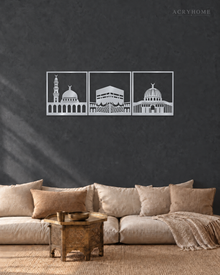 Three mirror silver acrylic panels showing the three holy mosques in architectural silhouette, arranged as a set on a light neutral wall.