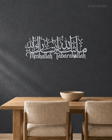 Mashallah Tabarakallah acrylic wall art in mirror silver, Arabic calligraphy above English script, float-mounted on a dark wall