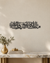 Mashallah Tabarakallah wall art in gloss piano black acrylic, a single wide line of Thuluth calligraphy float-mounted on a pale wall.