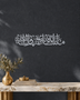 Mashallah Tabarakallah wall art in mirror silver chrome acrylic, a wide line of Thuluth calligraphy catching daylight on a neutral wall.