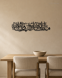Mashallah Tabarakallah wall art in gloss piano black acrylic, a single wide line of Thuluth calligraphy float-mounted on a pale wall.