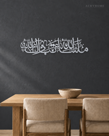 Mashallah Tabarakallah wall art in mirror silver acrylic, a wide line of Thuluth calligraphy catching daylight on a neutral wall.