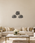 Three Quls Arabic calligraphy wall art in gloss black acrylic, one cluster above and two below, float-mounted on a pale wall.
