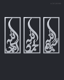 Set of three narrow vertical acrylic wall panels in mirror silver, each framing a single Arabic word in tall flowing calligraphy, float-mounted in a row on a pale wall.