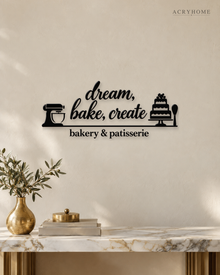 Bakery & Patisserie Wall Sign with Mixer and Cake in gloss piano black acrylic, float-mounted on a pale ivory wall.