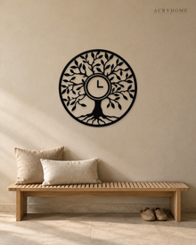 Tree of Life wall clock in gloss piano black acrylic, laser-cut leaf and branch work inside a circle, with the clock hands set into the centre of the trunk.