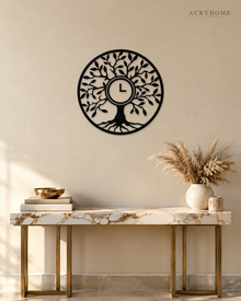Tree of Life wall clock in gloss piano black acrylic, laser-cut leaf and branch work inside a circle, with the clock hands set into the centre of the trunk.