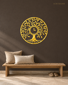 Tree of Life wall clock in mirror gold acrylic, fine laser-cut branches and leaves catching the light, clock face set into the centre of the trunk.
