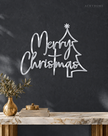 Merry Christmas Script Wall Sign with Outline Tree in mirror silver acrylic, float-mounted on a deep graphite wall.