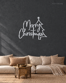 Merry Christmas Script Wall Sign with Outline Tree in mirror silver acrylic, float-mounted on a deep graphite wall.