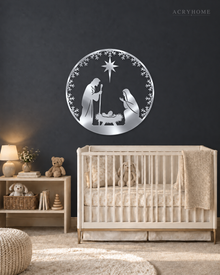 Round Nativity scene wall art in mirror silver acrylic — Mary, Joseph and the manger beneath the star, ringed by a pine and snowflake wreath, float-mounted on a pale wall.