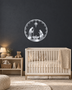 Round Nativity scene wall art in mirror chrome silver acrylic — Mary, Joseph and the manger beneath the star, ringed by a pine and snowflake wreath, float-mounted on a pale wall.