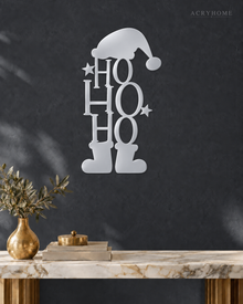 Ho Ho Ho Christmas Wall Art with Hat and Boots in mirror silver acrylic, float-mounted on a deep graphite wall.