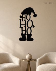 Ho Ho Ho Christmas Wall Art with Hat and Boots in gloss piano black acrylic, float-mounted on a pale ivory wall.