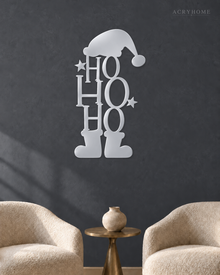 Ho Ho Ho Christmas Wall Art with Hat and Boots in mirror silver acrylic, float-mounted on a deep graphite wall.