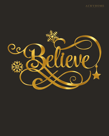 Believe in ornate flowing script with snowflake and flourish detail, laser-cut from mirror gold acrylic and float-mounted on a pale wall.