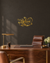 Believe in ornate flowing script with snowflake and flourish detail, laser-cut from mirror gold acrylic and float-mounted on a pale wall.