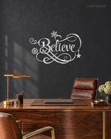 Believe in ornate flowing script with snowflake and flourish detail, laser-cut from mirror silver acrylic and float-mounted over a mantel.