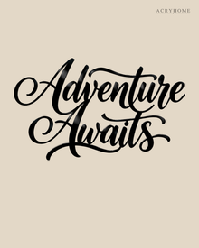 Adventure Awaits brush script wall art in gloss piano black acrylic, float-mounted above a console table on a pale plaster wall