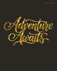 Adventure Awaits brush script wall art in mirror gold acrylic, float-mounted on a neutral wall with the flourishes catching warm light