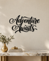 Adventure Awaits brush script wall art in gloss piano black acrylic, float-mounted above a console table on a pale plaster wall